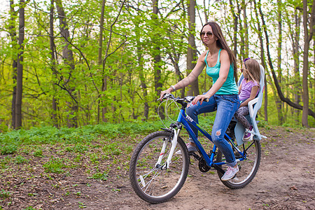 快乐的母亲和小女儿 在公园骑自行车的自行车童年父母喜悦妈妈活动女孩享受乐趣幸福骑术图片