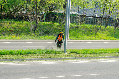 工人用保护面罩割草铺路图片