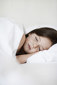 女孩睡在床上紧闭白色床罩就寝头发孩子睡眠一人睡衣房子棕色图片