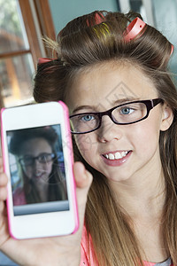 小女孩有毛发卷卷头发 用手机给自己拍照片图片