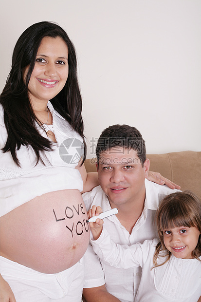 家庭与怀孕母亲一起在沙发上放松了对图片