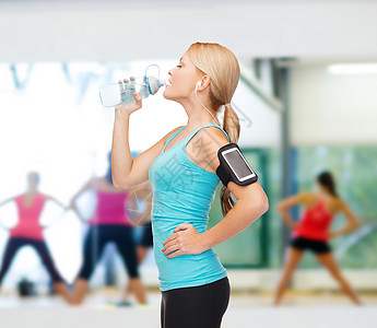 运动妇女用智能手机和耳机奔跑减肥训练音乐损失班级慢跑者播客健身房团体互联网图片