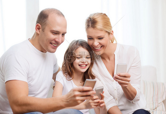 父母和家里有智能手机的小女孩的父母家庭母亲互联网男人妈妈成人电话青少年幸福女士图片