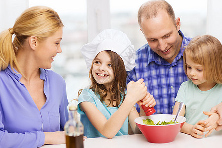 有两个孩子在家吃饭的幸福家庭午餐小吃父亲厨师男人父母母亲胡椒帮助微笑图片