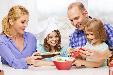 有两个孩子在家吃饭的幸福家庭女孩们父母午餐微笑教学母亲女士厨房父亲帽子图片