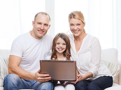 家里有笔记本电脑的父母和小女孩男性成人幸福上网互联网女儿女士童年技术妈妈图片