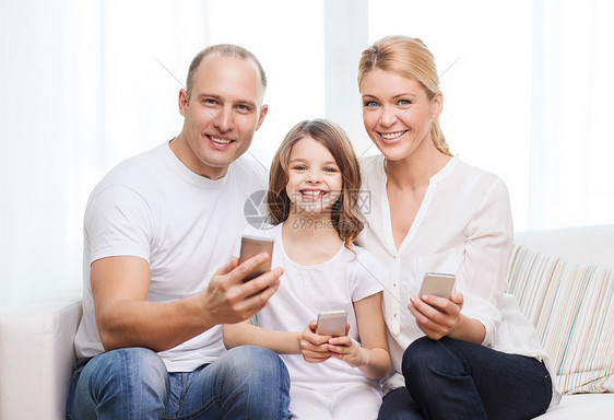 父母和家里有智能手机的小女孩的父母孩子女儿幸福技术童年母亲家庭妈妈互联网电话图片