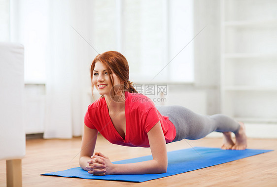 笑着笑着的红头红发少女女孩在家做木板灵活性减肥铺板运动身体耐力女性腹肌运动装平衡图片