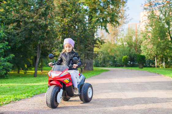 穿着皮夹克的小漂亮女孩 坐在玩具摩托车上的玩具婴儿姐姐速度自行车情感喜悦引擎孩子幼儿园乐趣图片