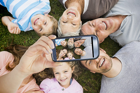 手持智能手机显示的复合图象快乐孙子父母电话圆圈父亲孙辈展示男性祖父图片
