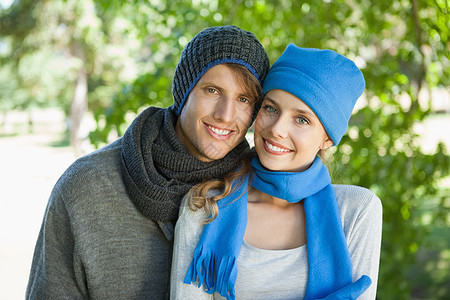 可爱的一对情侣笑着用帽子和围巾拍摄镜头男性公园浅色女朋友快乐男人金发棕色女士手套图片