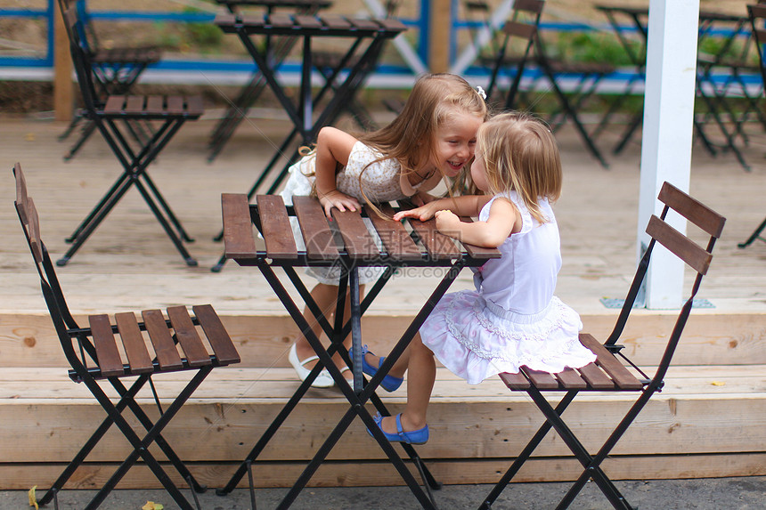 小快乐女孩在户外咖啡厅玩得开心闲暇快乐玻璃餐厅饮料童年女性父母幸福咖啡店图片