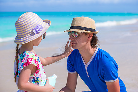 小女孩在父亲的鼻子上晒太阳霜奶油护理女儿晒斑紫外线家庭日光浴孩子假期男人图片