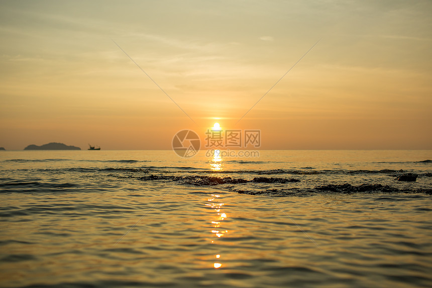 海上孤单的船黑色太阳天际时间晴天白色海浪蓝色反射场景图片