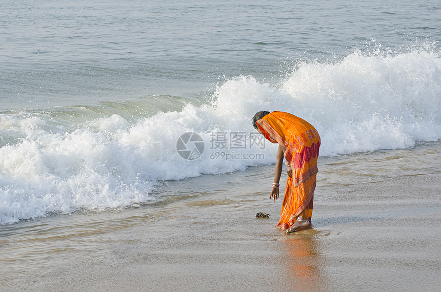 在海边有多彩色沙丽的印度女人图片