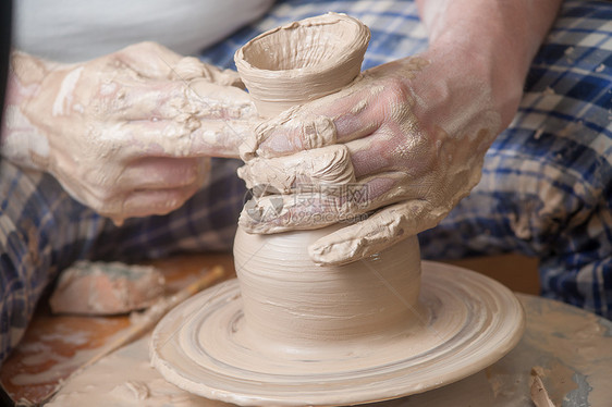 陶匠的手压力车轮专注艺术模具手工制造业黏土工作手工业图片