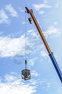 建筑工地Crane 吊起式混凝土桶货物平衡绳索钢筋金属机械工地工业建筑起重机背景