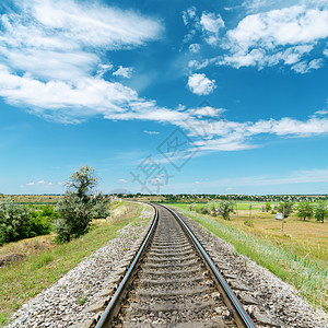 绿色地貌和蓝色天空白云的铁路图片