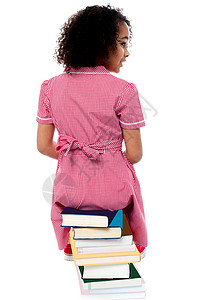 坐在书上的女孩坐在一堆书上的女孩的背面姿势背景