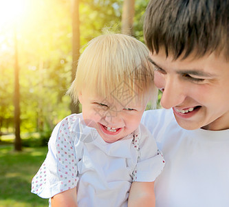 年轻父亲和婴儿幸福爸爸微笑公园拥抱童年喜悦孩子男人儿子图片