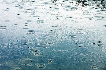 下雨天气风暴飞溅池塘液体反射雨滴涟漪水坑波纹蓝色图片