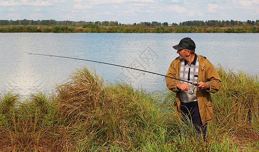 湖上带旋转棒的老渔夫图片