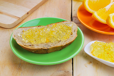 橙果酱和全草面包黄色食物甜点橙子早餐玻璃木头营养水果维生素图片