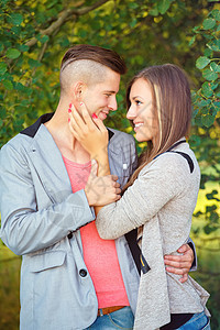 在户外微笑快乐的年轻夫妇太阳男朋友拥抱公园成人家庭幸福男人感情情侣图片