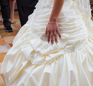 结婚日 新娘的手和婚戒在礼服上图片