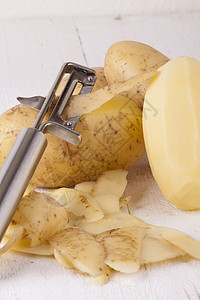 含有Peeler和Peeled皮肤的土豆饮食块茎果皮生产淀粉根菜金属厨房刀刃食物图片