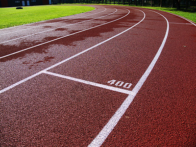 体育场的红色赛道竞赛网格短跑竞技场煤渣冠军马场运动员曲线赛跑者图片