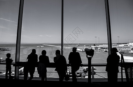 YVR机场内的人 观看空中卡塔达飞机 用黑色和枯燥的图片