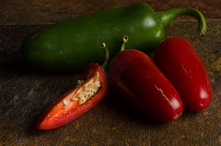 红色和绿色胡椒石头水果食物纹理辣椒香料背景图片
