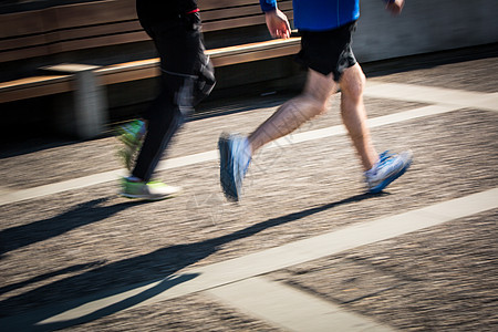 在城市环境中运动模糊的跑步者脚图片