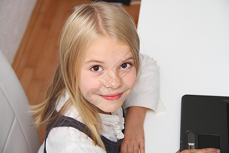 在家使用笔记本电脑的年轻女孩冲浪互联网女性微笑技术上网客厅水平沙发孩子图片