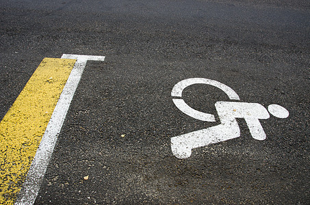 沥青路路路背景上的轮轮椅残疾人标志图片