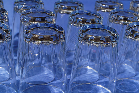 多玻璃杯反射饮料瓶子液体玻璃桌布派对器皿蓝色背景图片