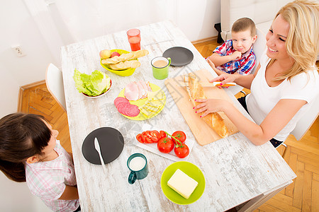 家人在家吃早饭快乐牛奶成人面包微笑父母男生童年厨房房子儿子图片