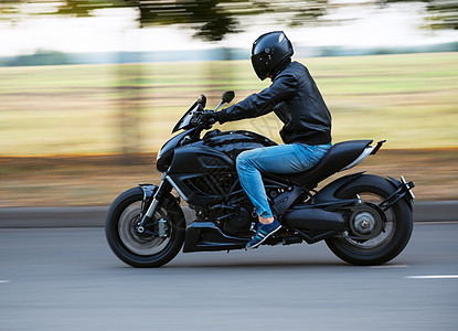 年轻人骑着运动摩托车在路上行驶图片