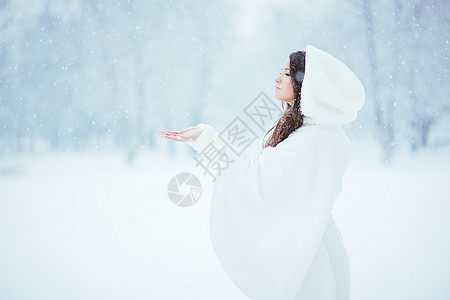 宁静长发女性女士雨披青年下雪戏服白色季节性雪花背景图片