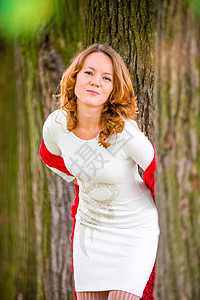 在树丛中穿白衣服的红头发女孩图片