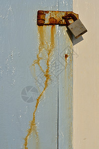 蓝色门上的隔锁安全风化金属木头古董图片