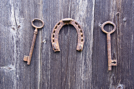 两把古老的历史钥匙和幸运符号 墙上的马蹄木记忆钥匙圈农场谷仓安全出口木头隐私工具古董背景图片