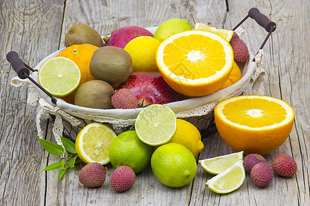 新鲜水果 篮子里有新鲜的果实热带石榴食物杂货店橙子酸橙荔枝奇异果柿子柳条图片