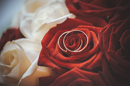 两只结婚戒指在花束上背景图片