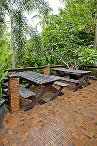 木制椅子和桌放在一个绿色植物园的阳台上休息甲板家具植物衬套地面咖啡店扶手椅池塘桌子图片
