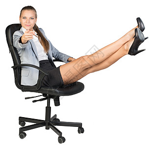 女商务人士坐在办公椅子上 双脚抬起 用手指对着照相机背景图片