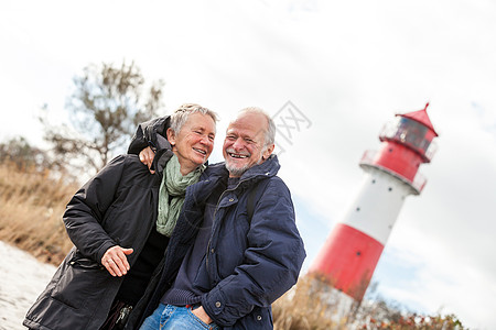快乐的成熟情侣 放松黄海沙丘退休夫妻海岸微笑旅行女性假期蓝色成人天空图片