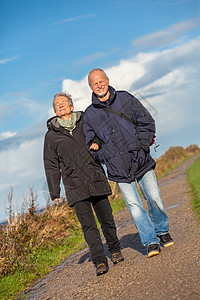 快乐的成熟情侣 放松黄海沙丘成人夫妻乐趣老年退休假期女性蓝色长者旅行图片