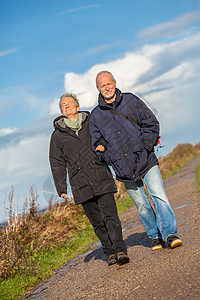 快乐的成熟情侣 放松黄海沙丘微笑海岸闲暇假期老年天空活力女性退休旅行图片